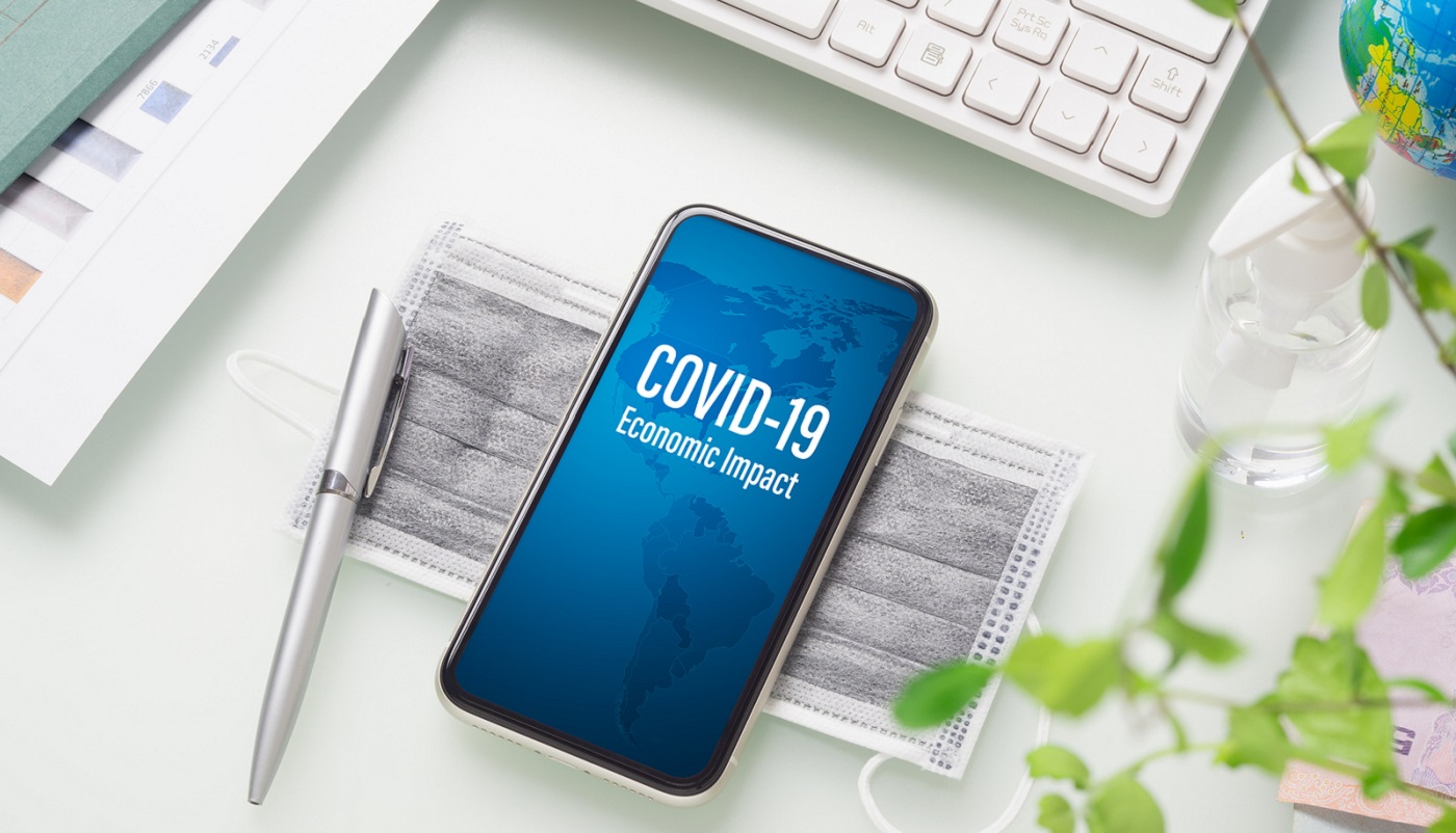 Covid-19 Or Corona Virus Economic Impact Background Concept. Moc COVID-19 or Corona virus ECONOMIC IMPACT background concept. Mockup mobile phone for Covid 19 business impact with facial masks and Alcohol Mini Hand Sanitizer gel on working office desk table workspace.